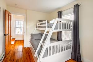 ストーニントンにあるCheerful Historic 3 BR Townhouse Downtown Mysticの二段ベッド2台と窓のある寝室