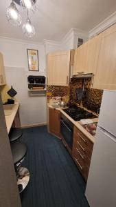a kitchen with wooden cabinets and a stove top oven at Apartament 22 Stycznia 3 in Przemyśl