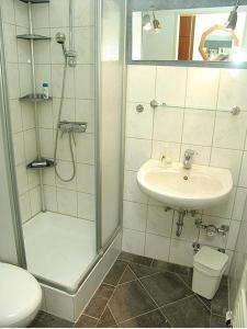 a bathroom with a shower and a sink and a toilet at Ferienwohnung Möwenschiss - Haus Bake in Büsum