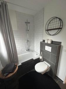 a bathroom with a tub and a toilet and a sink at Cosy Bungalow-Apartment in ruhiger Toplage - nähe Düsseldorf in Krefeld