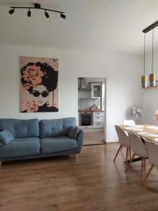 a living room with a blue couch and a table at Hunor Vendégház in Golop