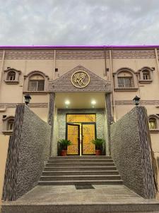 a building with a yellow door with stairs in front at شقق خزامى الباحة in Al Baha