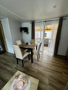 a living room with a dining room table and chairs at Mobile-home 3 chambres chaleureux et calme in Seillac