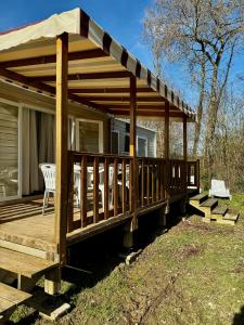 a wooden deck with a pavilion on a house at Mobile-home 3 chambres chaleureux et calme in Seillac