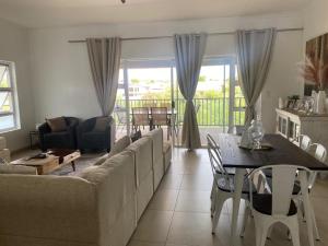 una sala de estar con un sofá y una mesa en Windhoek Holiday Apartment, en Windhoek 3 fotos más