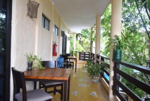 eine Veranda mit einem Holztisch und Stühlen in der Unterkunft Hotel Casa el Moro in Puerto Morelos