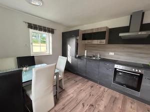 a kitchen with a table and chairs and a counter at Weberhaus im Zirbenland in Weißkirchen in Steiermark +11 photos