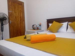 cuscino arancione, posto sopra un letto di ALEXANDRA HOME for foreign tourists only a Gampola