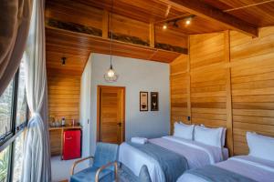 DivisaにあるVilla di Madeiraの木製の壁の部屋にベッドが2つある