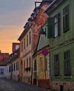 Un grupo de edificios en una calle con un cartel de calle. en Wall St House, en Sibiu