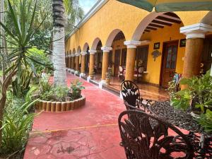 a courtyard of a building with chairs and plants at Casa Palagui Colonial in Valladolid