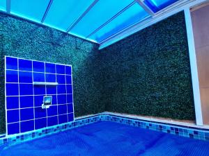 a swimming pool with a blue tile wall at Casa LuPi in Carmo do Rio Claro