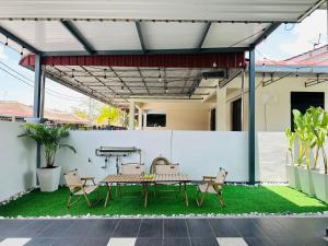 大山脚BM大山脚 Alma Single Storey Semi-D 5-minute To Aeon Mall的庭院设有野餐桌和草坪上的椅子