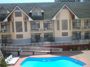 Gold Crest Hotel - Arusha في أروشا: عمارة سكنية امامها مسبح