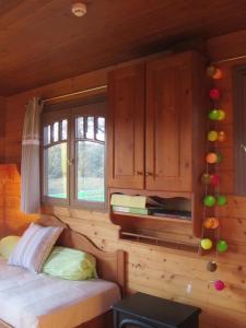 Dormitorio con cama y ventana en una cabaña en La roulotte d'Alcas en Saint-Jean-et-Saint-Paul