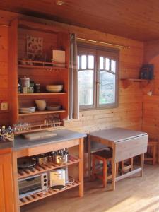 uma cozinha com um balcão e uma mesa num quarto em La roulotte d'Alcas em Saint-Jean-et-Saint-Paul