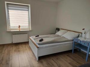 a bedroom with a bed and a window and a table at Apartament z pianinem in Grajewo