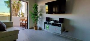 a living room with a tv and a couch at Modern 2BR Apartment Private Parking Walk to Dona Ana Beach & Lagos Old Town in Lagos