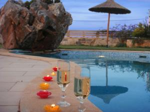 two glasses of wine sitting next to a swimming pool at Villa Valentine in Hersonissos