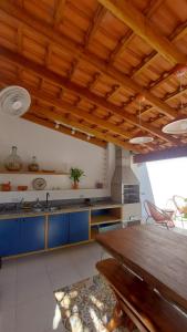 a kitchen with blue cabinets and a wooden ceiling at Casa da XV - Iguape, S.P in Iguape