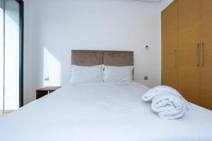 Beni BrourにあるAppartement Royalのタオルが敷かれた白いベッドのある寝室