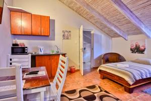 a kitchen and a bedroom with a bed and a table at Anandi Guesthouse Swakopmund in Swakopmund