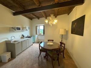una cucina con tavolo, sedie e lavandino di La Corte del Castello di San Michele a San Michele in Teverina