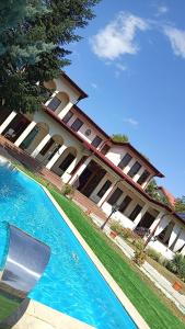 un grande edificio con una piscina di fronte di Vila Arcada Otp a Otopeni