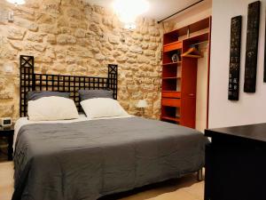 a bedroom with a bed and a stone wall at Appartement clair et lumineux au centre de Paris in Paris