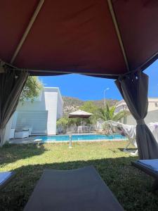 Dar el KoudiaにあるVilla Deluxe, pool, spacious garden, mountain viewの傘の下から見たプールの眺め