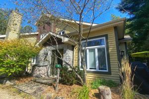 een klein huisje met een boom ervoor bij Condo cottage-style Tremblant in Saint-Jovite