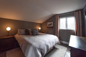 een slaapkamer met een groot bed en een raam bij Condo cottage-style Tremblant in Saint-Jovite +18 foto's