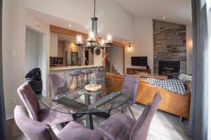 een eetkamer met een glazen tafel en stoelen bij Condo cottage-style Tremblant in Saint-Jovite