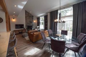 een woonkamer met een glazen tafel en stoelen bij Condo cottage-style Tremblant in Saint-Jovite