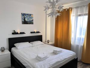 a bedroom with a large bed with towels on it at Comfortable Baia Mare Apartment in Baia Mare