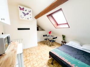 a bedroom with a bed and a window and a table at Anh Dao 3 - Studio, centre ville, tiamconciergerie in Champs-Sur-Marne