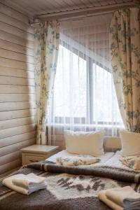a bedroom with a bed and a window with curtains at Mountain Cottage in Yaremche