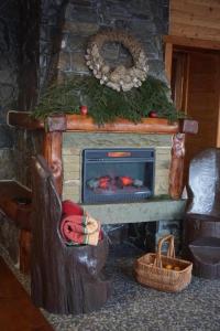a stone fireplace in a room with a christmas centerpiece at Mountain Cottage in Yaremche