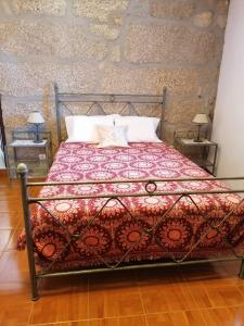 a bed with a red blanket and two pillows at Villa Cantinho dos Avós in Baião