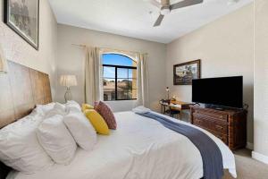 Un dormitorio con una cama grande y un televisor de pantalla plana. en La Quinta Gem 1 BR Pool Hot Tub Sleeps 4, en La Quinta