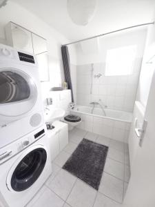 a white bathroom with a washing machine and a sink at Top! Wohnung direkt am Fuß der Berge im Oberallgäu in Immenstadt im Allgäu