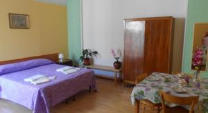 a bedroom with a purple bed and a table at B&B Fenice Barocca in Lecce