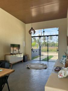 a living room with a couch and a table and glass doors at Casa Areia Bela - Patacho in Pôrto de Pedras