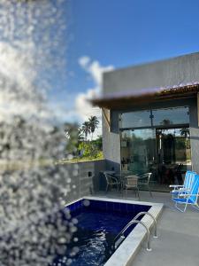 a house with a swimming pool next to a patio at Casa Areia Bela - Patacho in Pôrto de Pedras