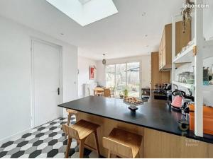 a kitchen with a black counter top in a room at Maison rénovée 7P Proche de Lille in Tourcoing