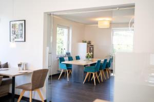 a dining room with a table and blue chairs at Lahn Hotel in Biedenkopf