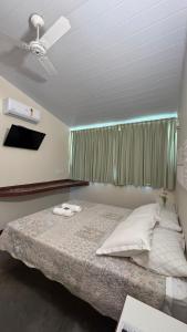 ein Schlafzimmer mit einem Bett mit Deckenventilator in der Unterkunft Pousada Verbicaro in Santa Maria Madalena