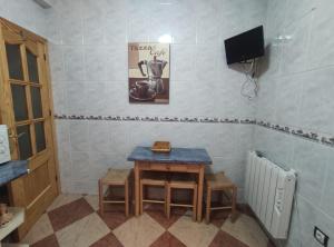 a small table and stool in a room with a television at ALQUILER CASA PEPA EN CAZORLA in Cazorla