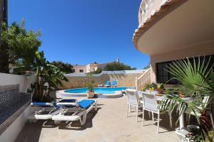 Un patio con sillas y una piscina. en Quinta do Sol, en Armação de Pêra