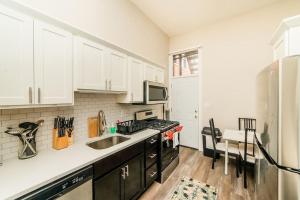 una cucina con mobili bianchi, un lavello e un frigorifero di Studio Suite - No Steps - Walkable & Free Parking a Pittsburgh
